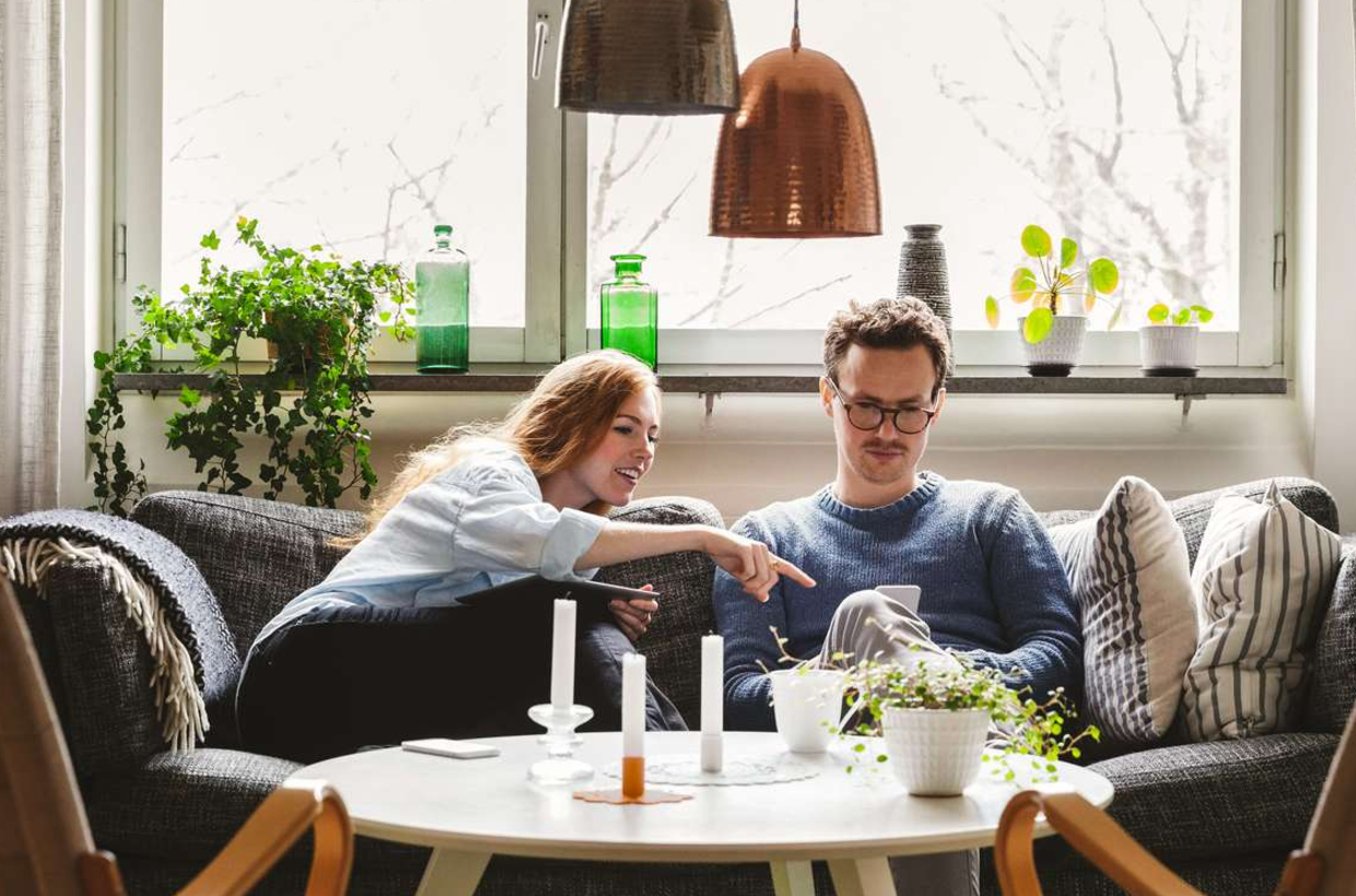 Billede af mand og kvinde ved sofabord - rentetilpasning i Totalkredit